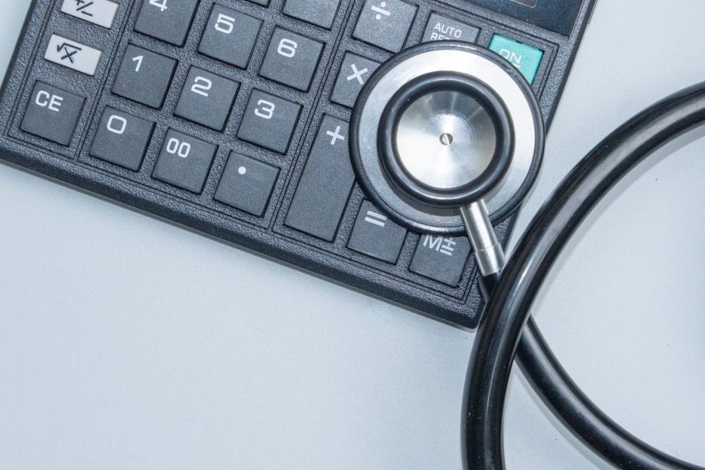 Medical stethoscope beside calculator representing vasectomy cost breakdown